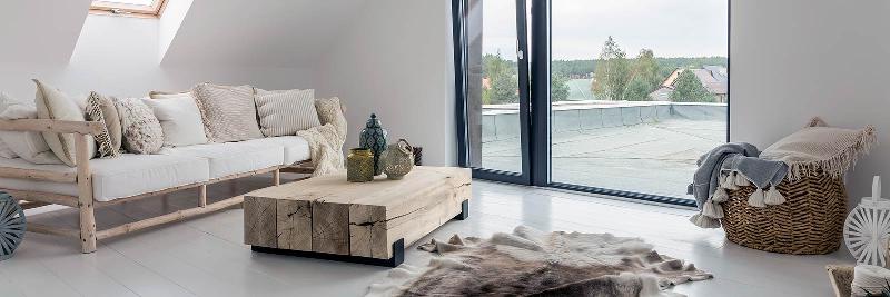 Une pièce sculpturale moderne de grande taille en bois flotté, placée dans un salon bohème-chic, apportant une texture naturelle et un élément organique à l’espace.